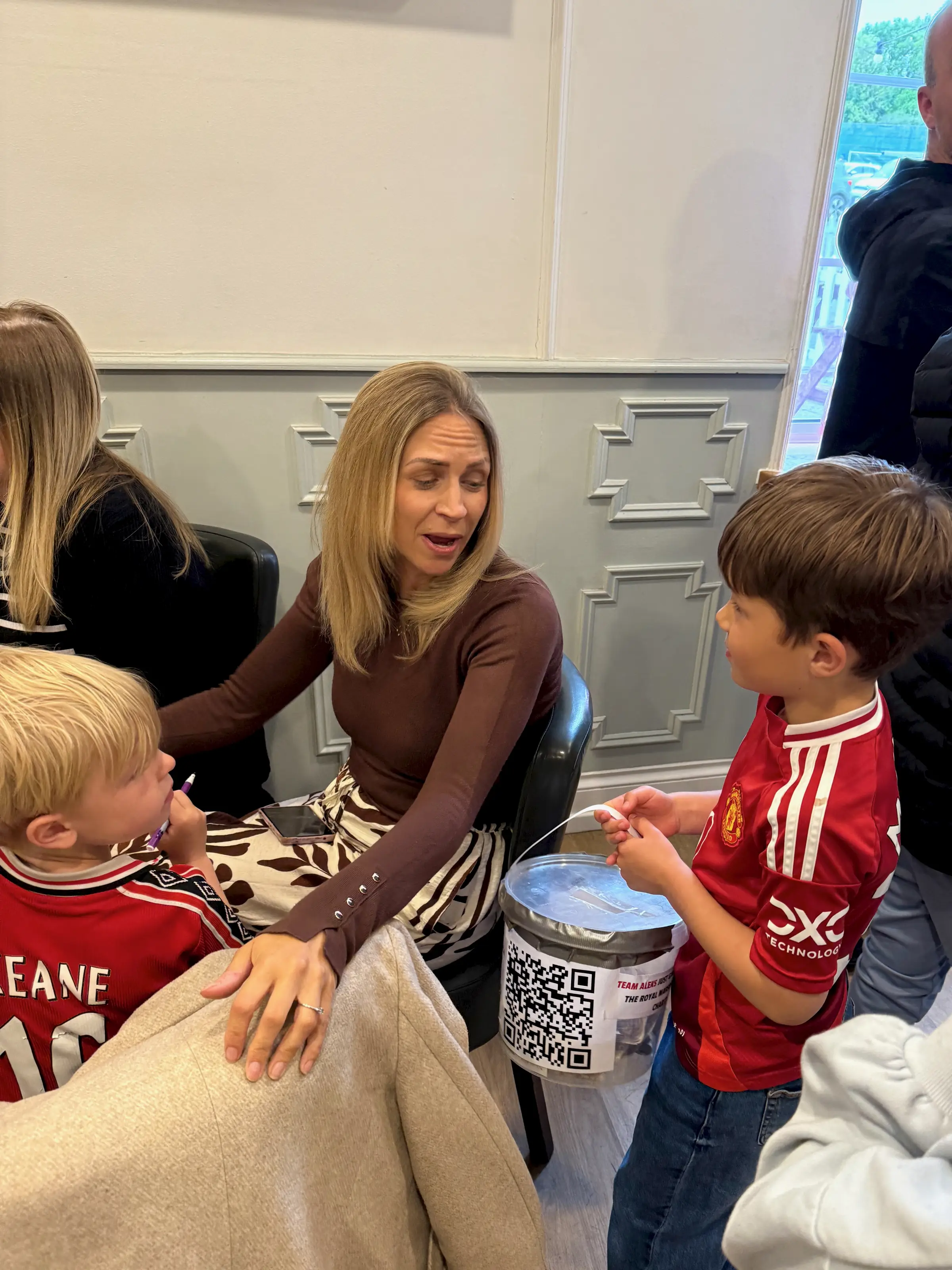 One of Aleks's friends taking the bucket round the pub - a supporter mid-donation, the kind of quiet moment that adds up fast