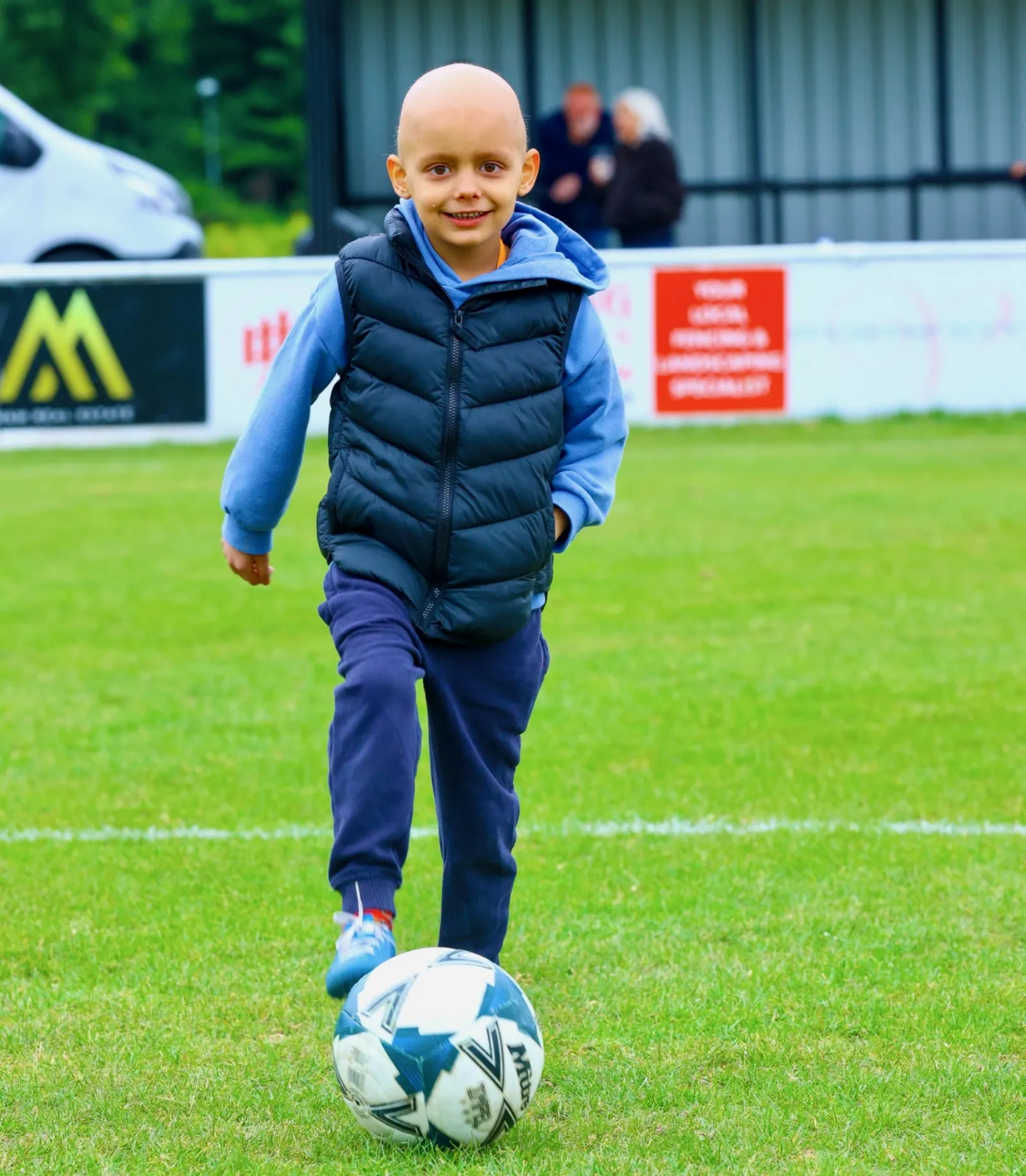 Aleks showing off his football skills, chasing the ball with a smile