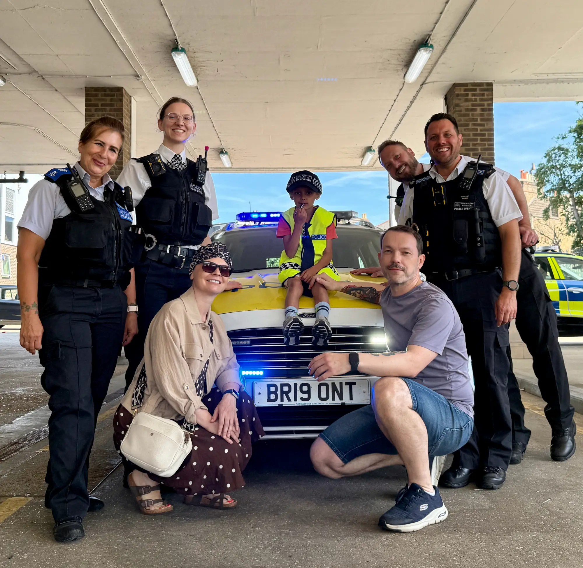 Perched on the bonnet with Mum and Dad and the officers who made the day, blue lights and all. 💙