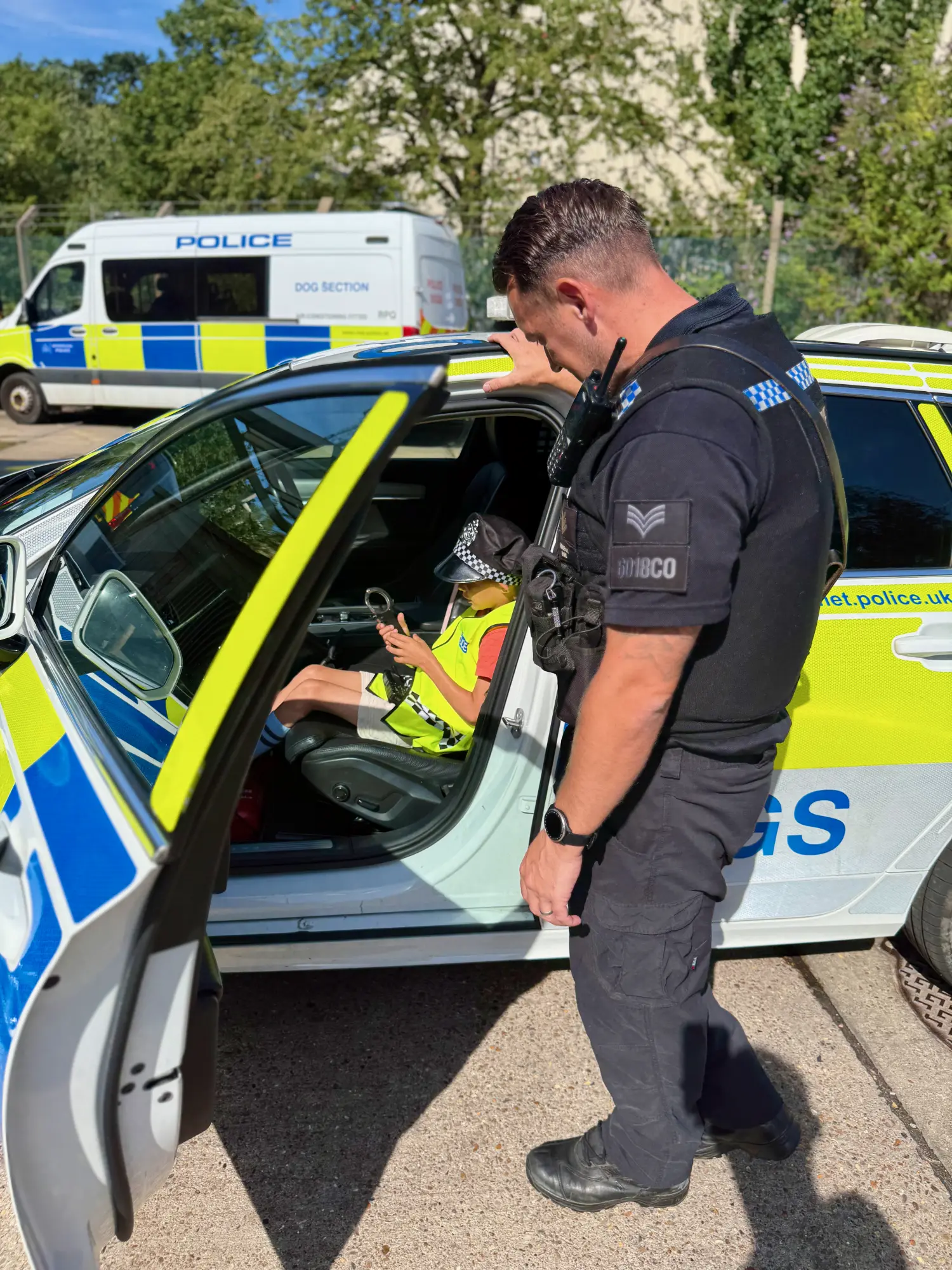Kitted out beside the 'DOGS' patrol car, handcuffs in hand and ready for his first callout.