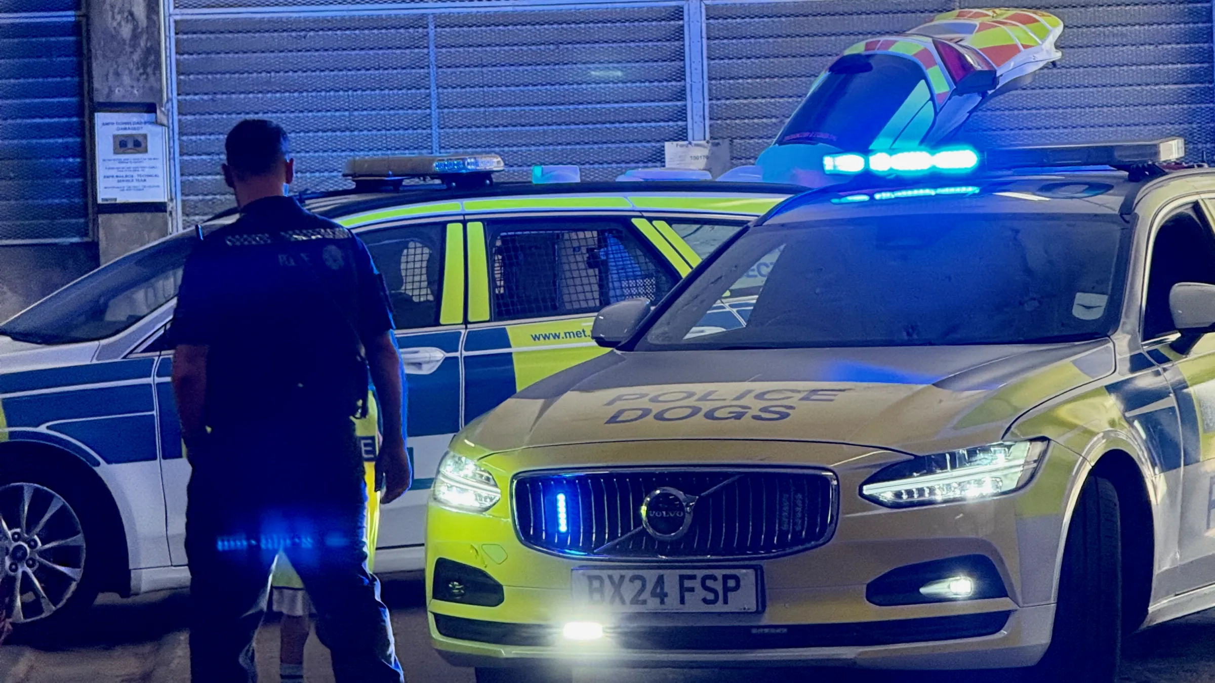 The scene Aleks walked into - a Metropolitan Police Dog Section unit under strobing blue lights, and one very small officer heading straight for the action.