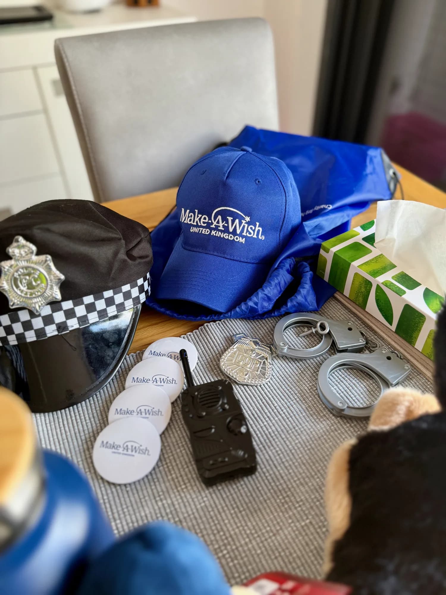 The day's treasures back home - helmet, badge, cuffs, radio, and the police dog that has not left his side since. 💛