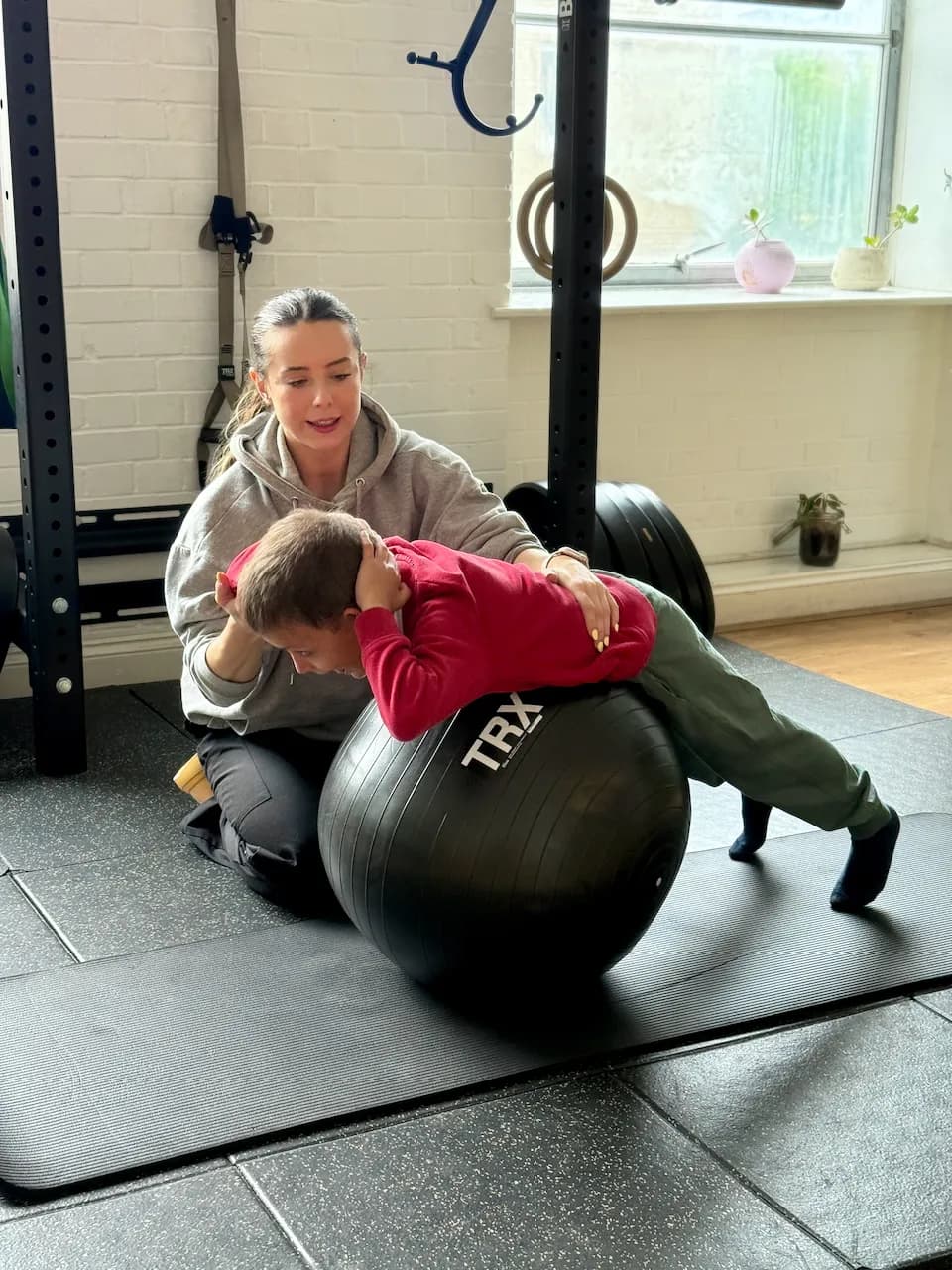 Stretch over the gym ball - opening up the chest and back, with Gabi taking the weight as he hangs forward.