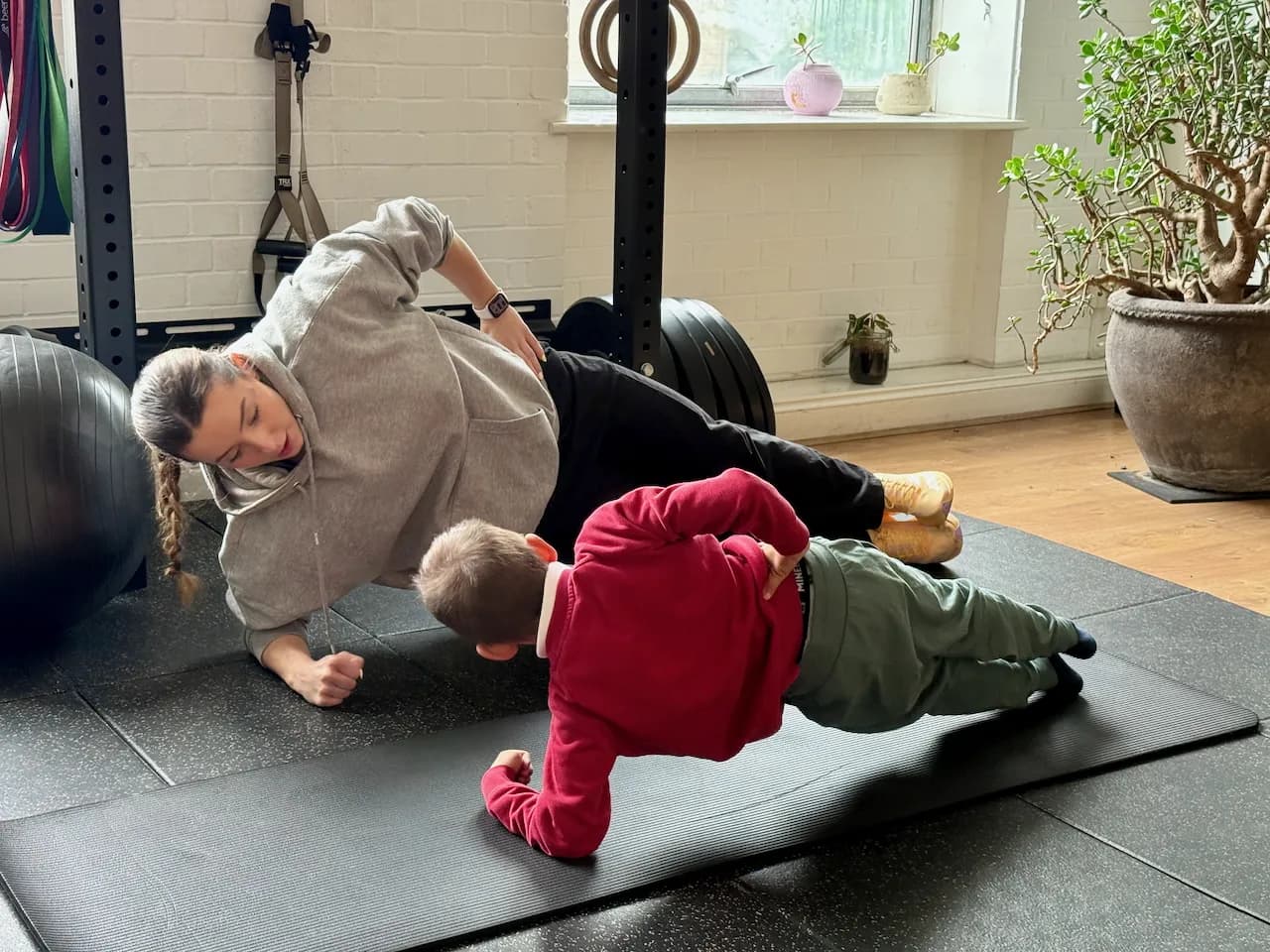 Side plank - Gabi shadowing the position from underneath, helping him hold form through the wobble.